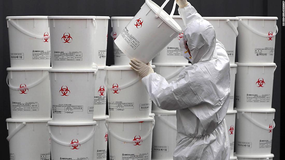 A worker in Daegu stacks plastic buckets containing medical waste from coronavirus patients on February 24.